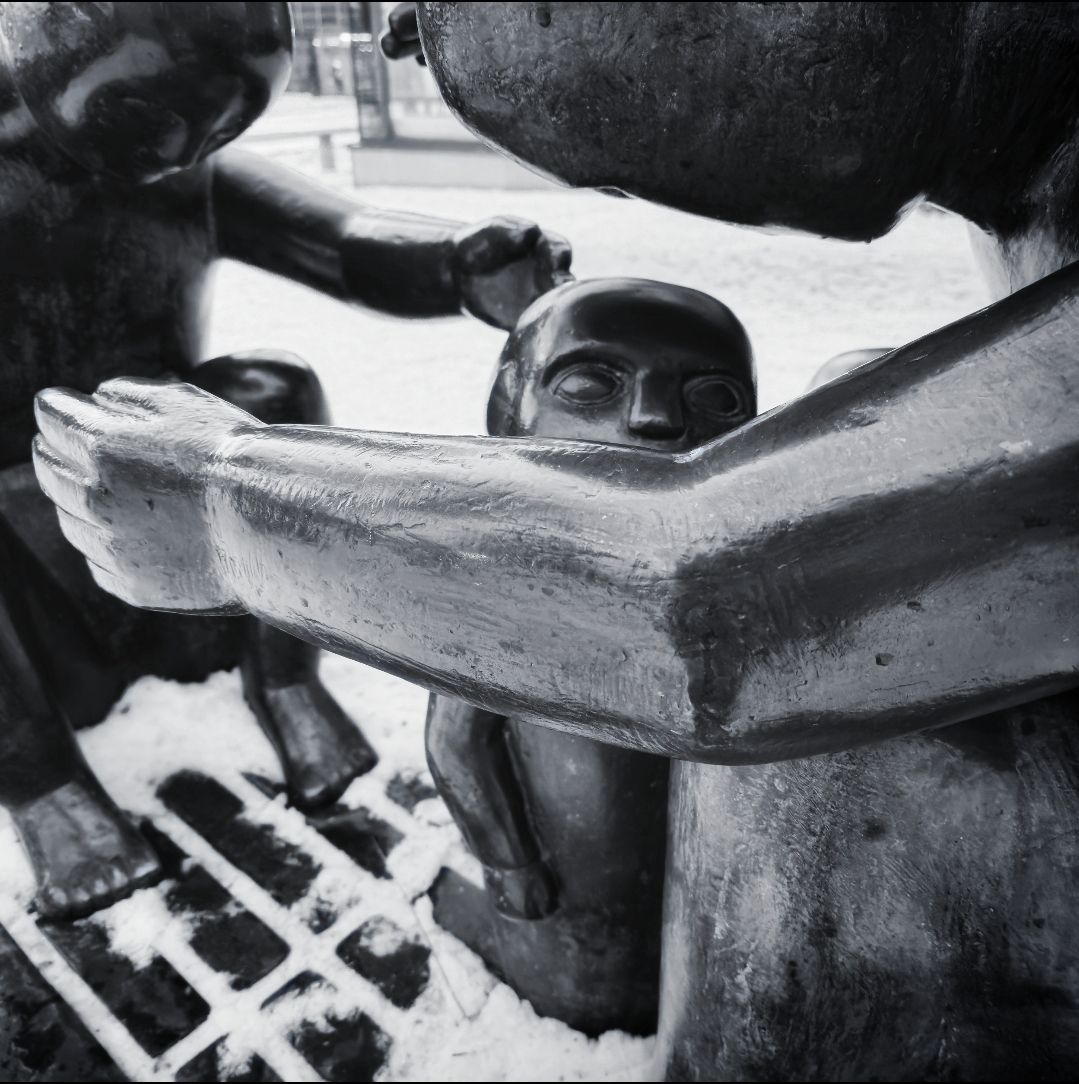 close up black and white photograph of metal sculpture of family